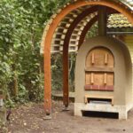 Lehmbackofen unter einem Tonnendach.