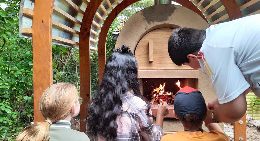 Schüler vor ihrem Lehmbackofen.